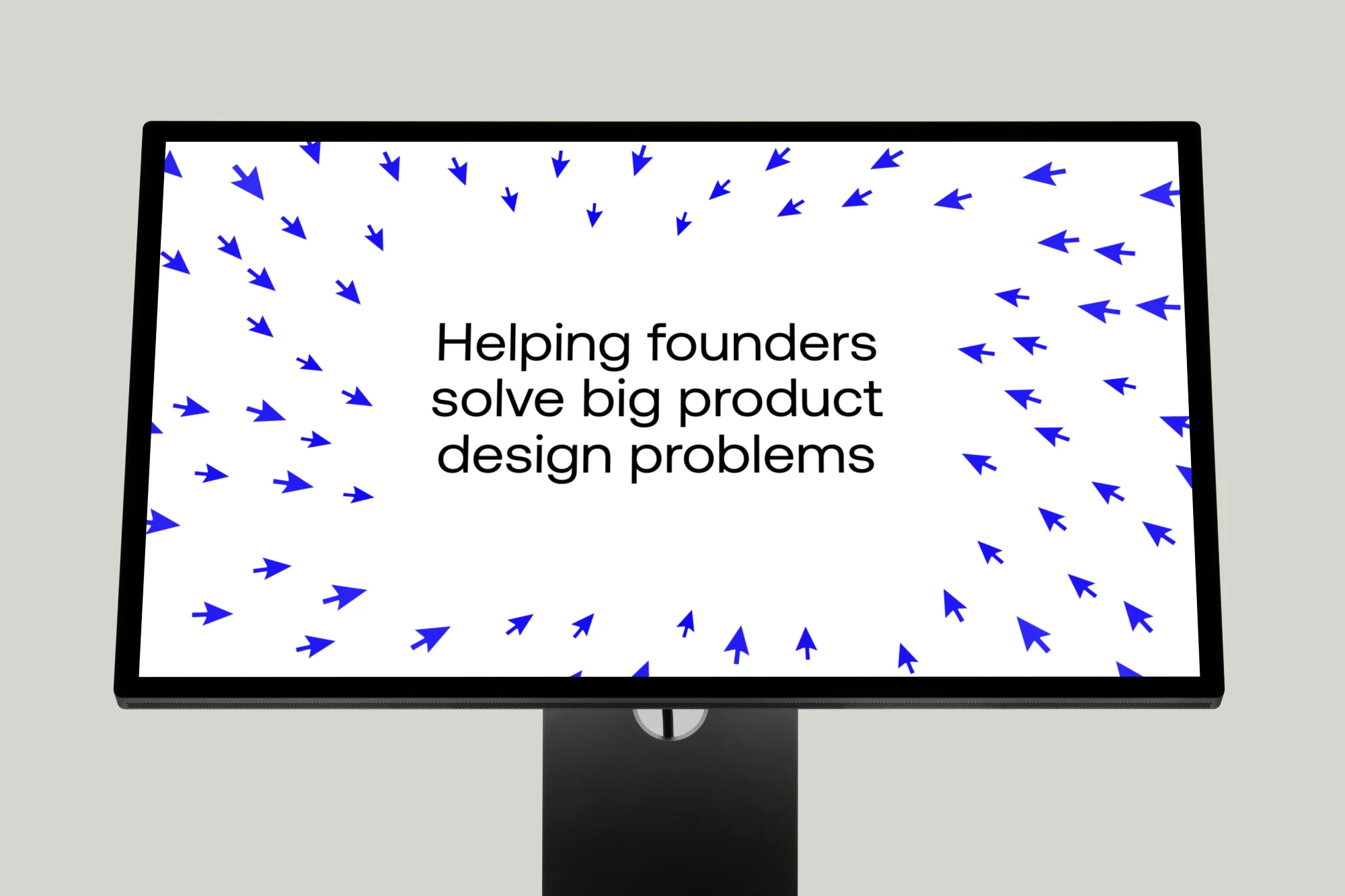 A desk monitor showing “Helping founders solve big product design problems” inside a ring of blue cursor arrows.